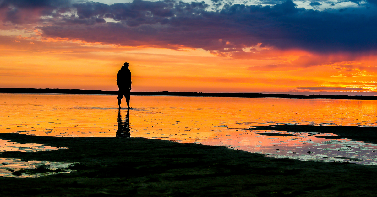 silueta de un hombre en un atardecer en el parque nacional del mar de Wadden (o de Frisia) en Dinamarca