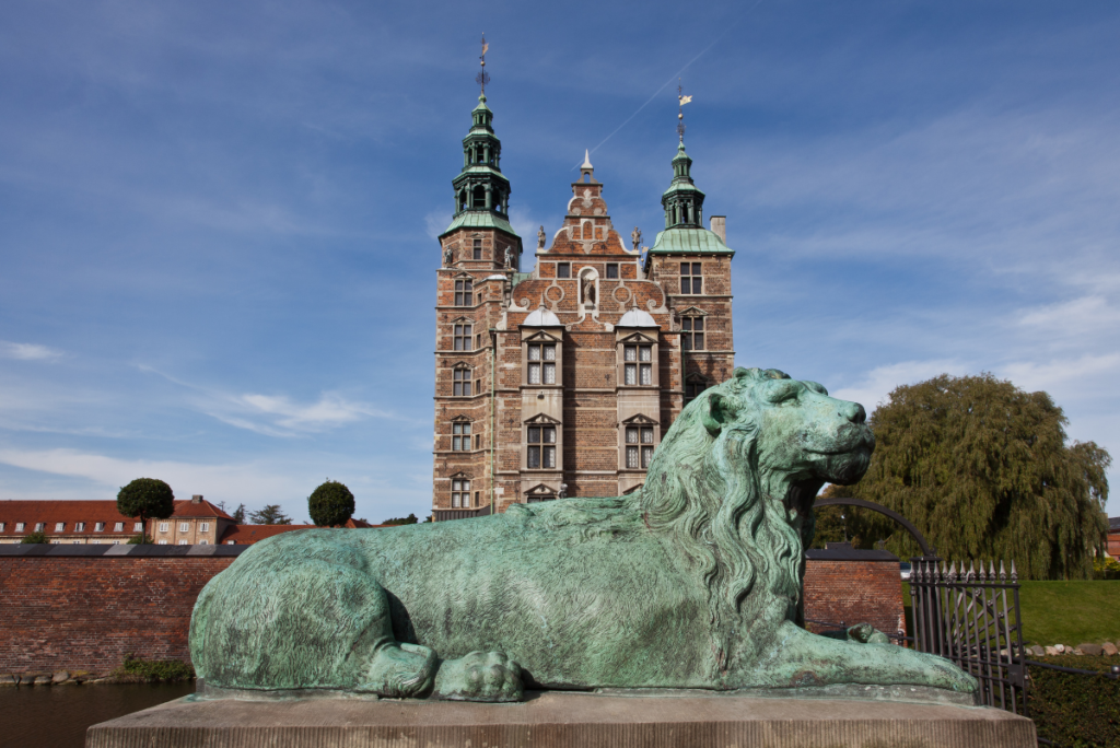 Castillo de Rosenborg con estatua de león de bronce en primer plano