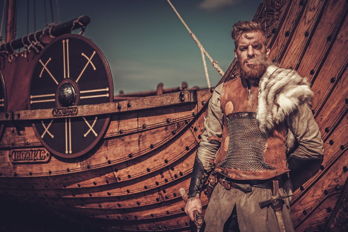 Hombre vikingo con barco drakkar al fondo